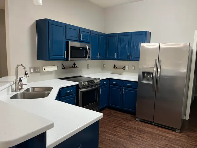 a kitchen with a refrigerator sink and wooden cabinets