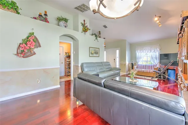 a living room with kitchen island furniture and a chandelier