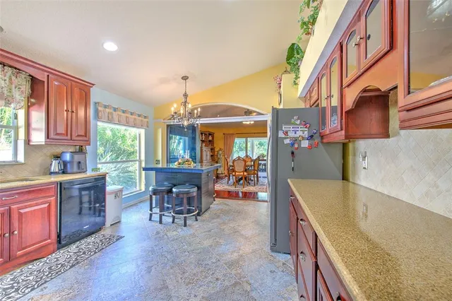 a view of a dining room with furniture a chandelier and large windows