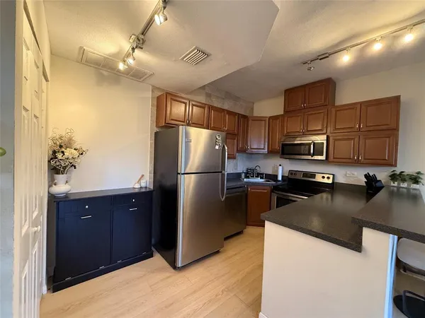 a kitchen with a refrigerator a stove a sink and a microwave
