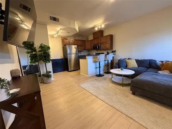 a living room with furniture a flat screen tv and kitchen view