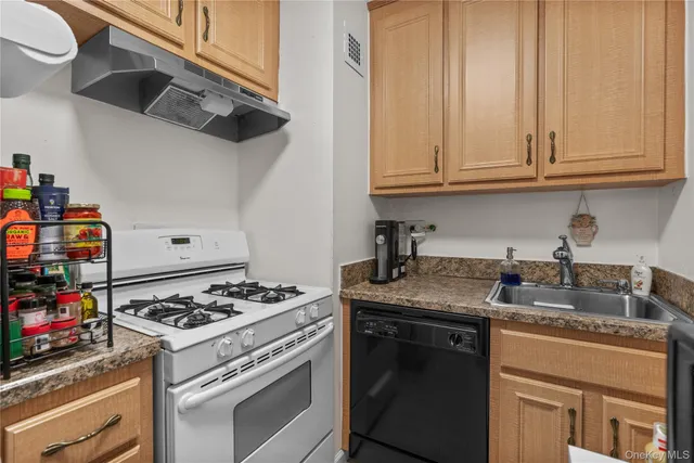 a kitchen with stainless steel appliances granite countertop a stove and a white cabinets