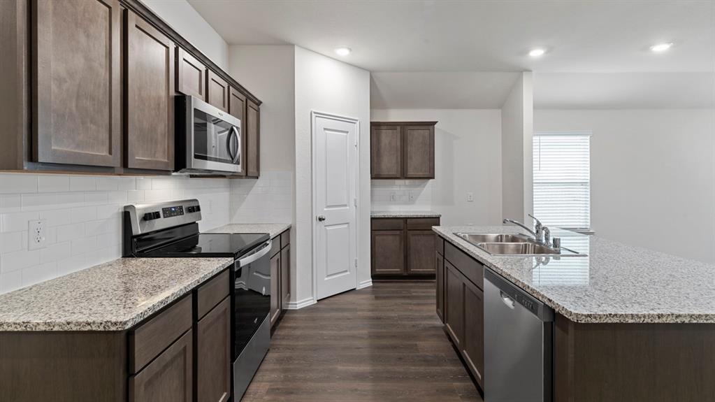 4028 Ripplewood Drive Lindale, TX 75771 - Photo 23 of 31 Kitchen featuring wood-finish flooring, granite countertops, stainless steel appliances, a subway tile backsplash, and recessed lighting