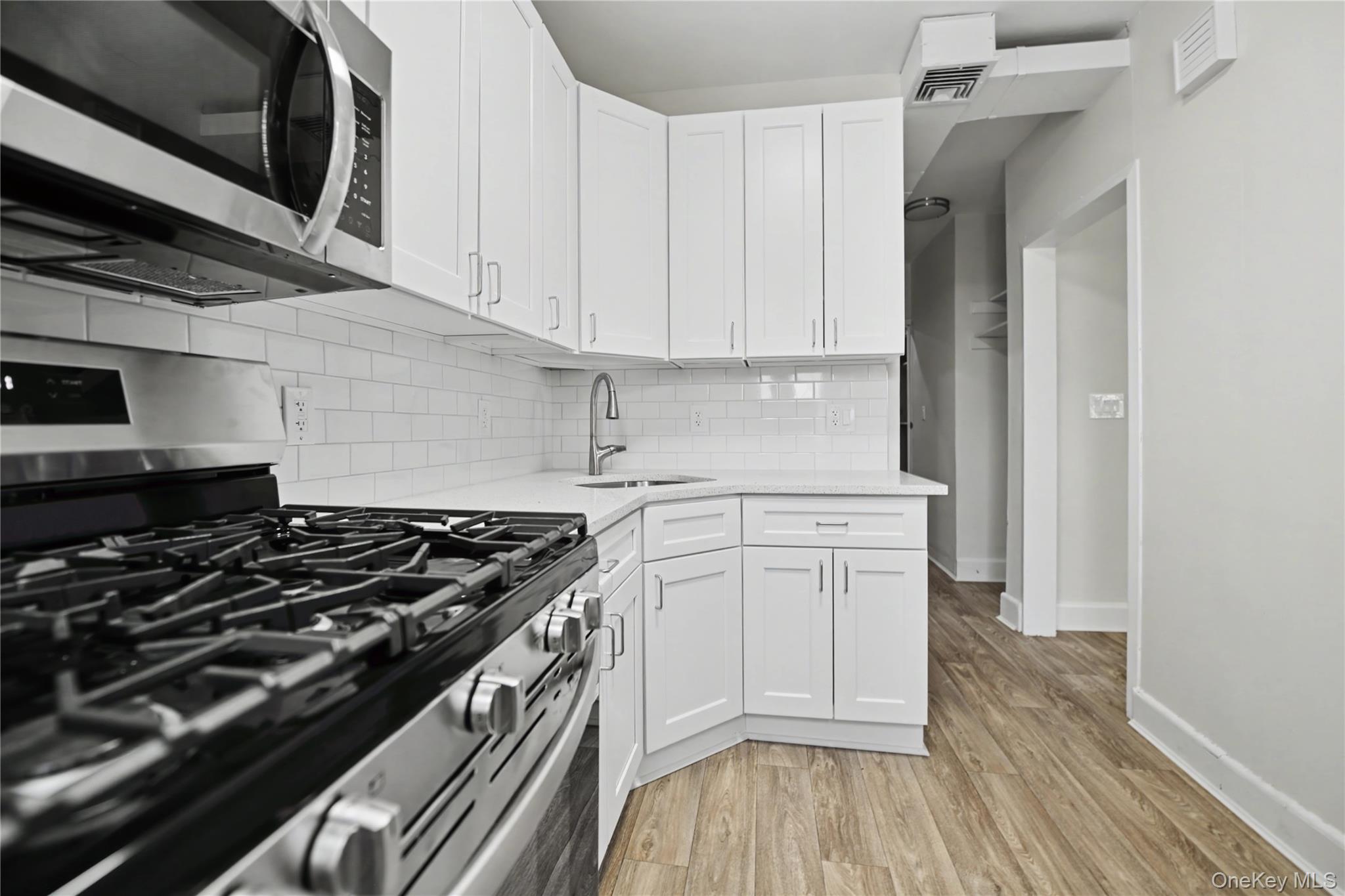 79-47 68th Road Queens, NY 11379 - Photo 14 of 29 a kitchen with a stove and a microwave
