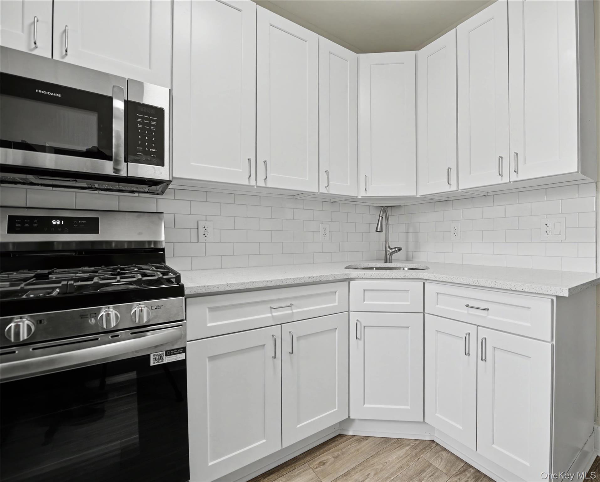 79-47 68th Road Queens, NY 11379 - Photo 15 of 29 a kitchen with white cabinets and stainless steel appliances