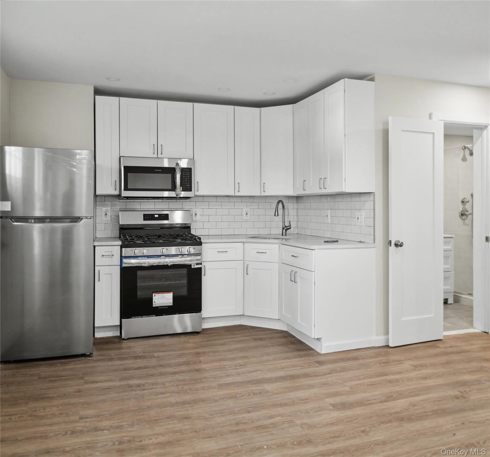 79-47 68th Road Queens, NY 11379 - Photo 5 of 29 a kitchen with cabinets stainless steel appliances and wooden floor