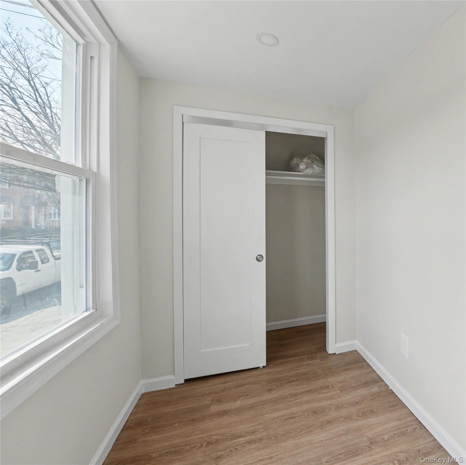 79-47 68th Road Queens, NY 11379 - Photo 10 of 29 a view of an empty room with wooden floor and a window