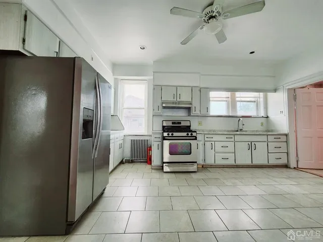 a kitchen with stainless steel appliances a refrigerator sink and cabinets