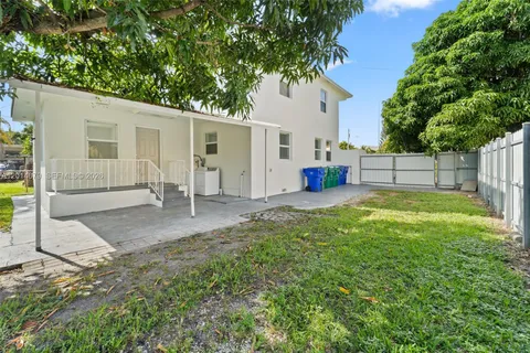 a view of a house with backyard and a tree
