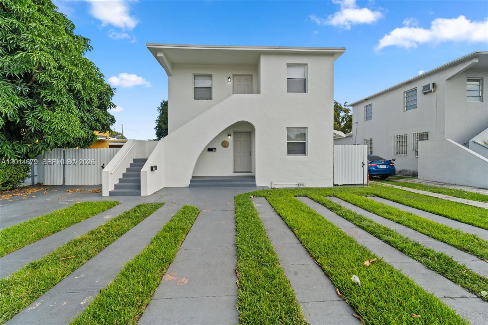 255 Beacom Boulevard, Unit DOWNSTAIRS Miami, FL 33135 - Photo 2 of 36 a front view of a house with a yard