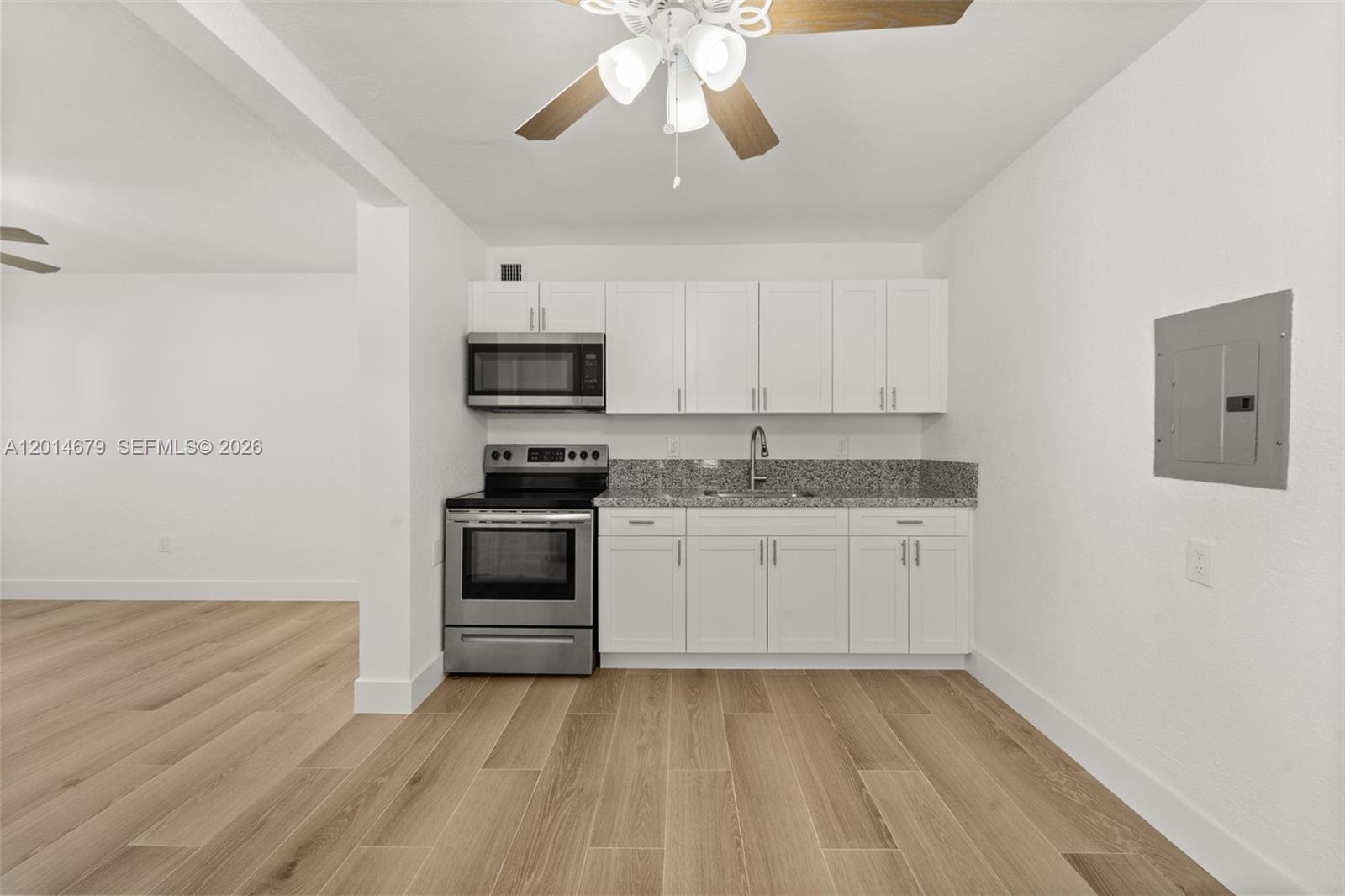 255 Beacom Boulevard, Unit DOWNSTAIRS Miami, FL 33135 - Photo 3 of 36 a kitchen with granite countertop a stove and a microwave oven
