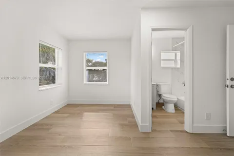 a view of a room with wooden floor and a toilet