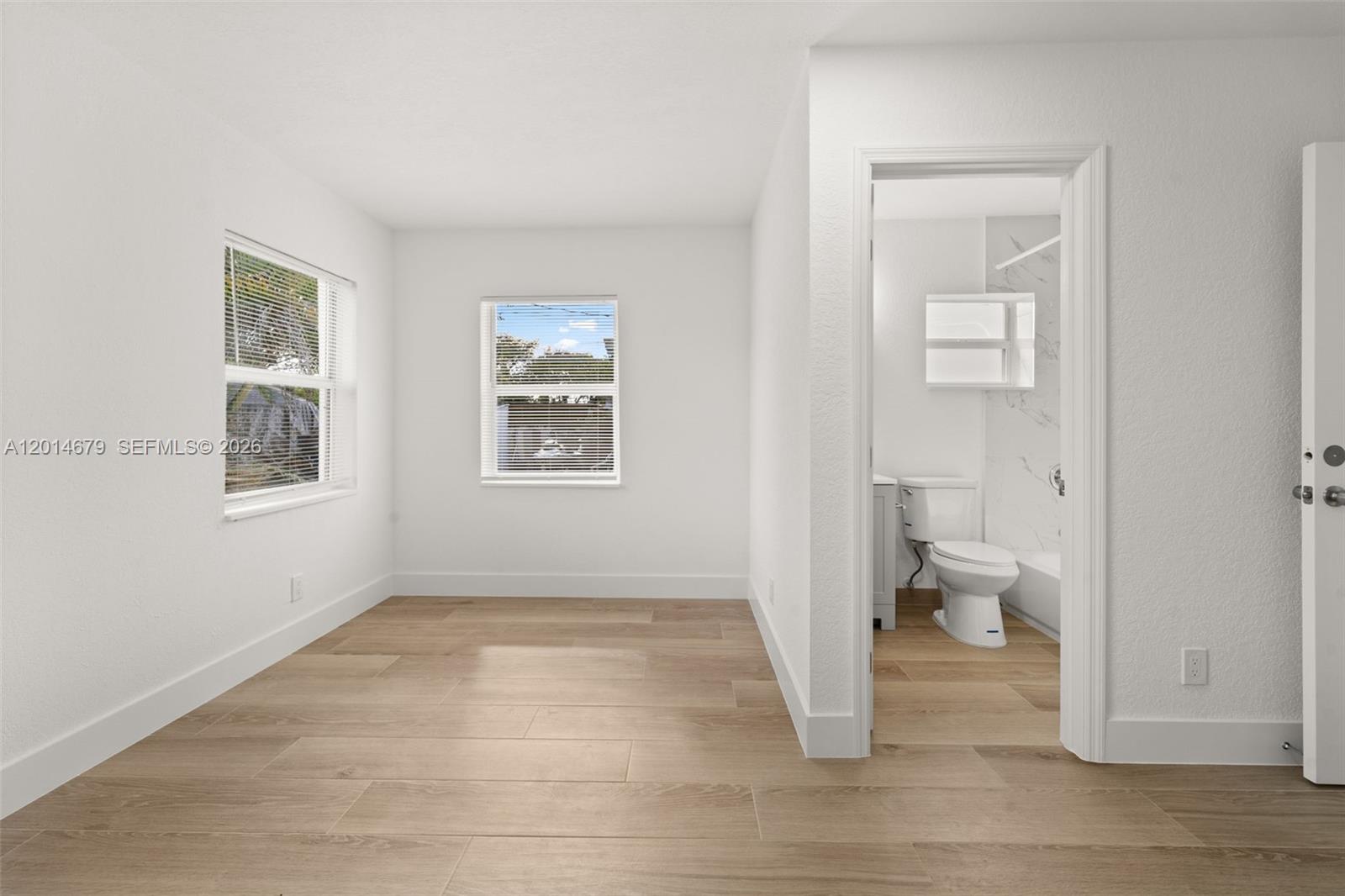 255 Beacom Boulevard, Unit DOWNSTAIRS Miami, FL 33135 - Photo 32 of 36 a view of a room with wooden floor and a toilet