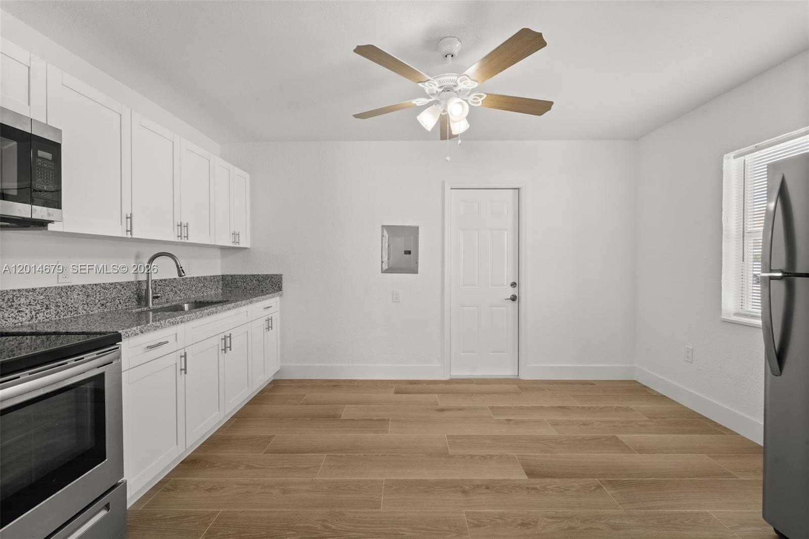 255 Beacom Boulevard, Unit DOWNSTAIRS Miami, FL 33135 - Photo 4 of 36 a kitchen with granite countertop white cabinets stainless steel appliances and a sink