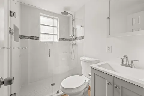 a bathroom with a toilet sink vanity and shower