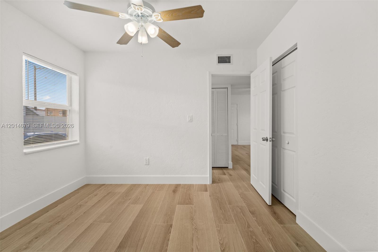 255 Beacom Boulevard, Unit DOWNSTAIRS Miami, FL 33135 - Photo 10 of 36 wooden floor in an empty room with a window
