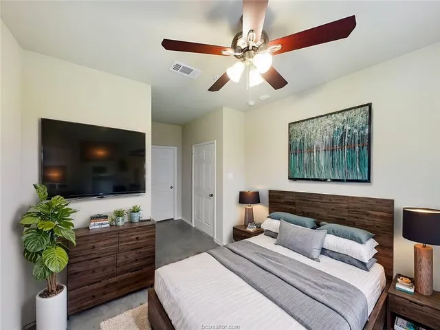 a bedroom with a bed and a flat screen tv