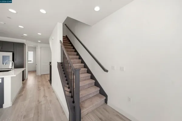 a view of a hallway with wooden floor and staircase