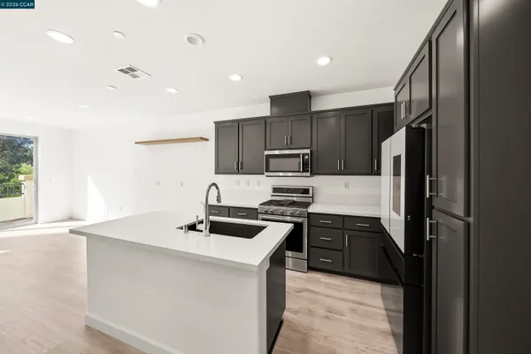 a kitchen that has a sink stainless steel appliances a counter space and a window