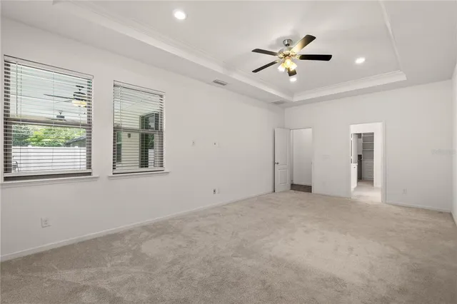 a view of an empty room with a ceiling fan and window