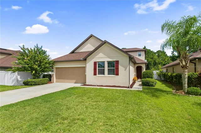 a view of a house with a yard and potted plants