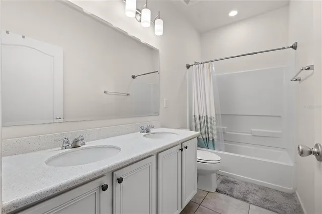 a bathroom with a granite countertop sink a toilet a mirror and shower