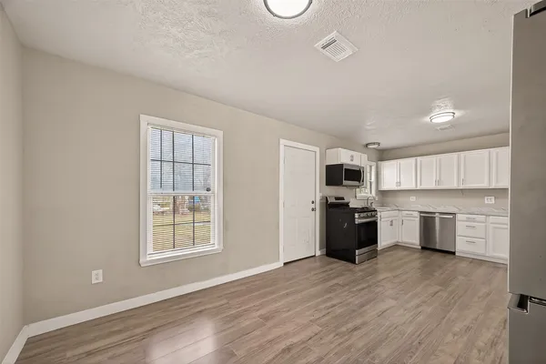 a kitchen with a refrigerator and a stove top oven