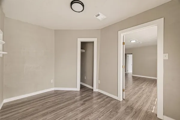 an empty room with wooden floor and mirror
