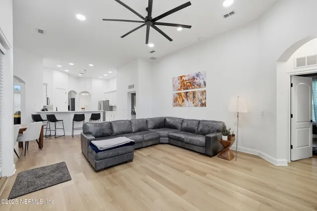 a living room with furniture a flat screen tv and a large window