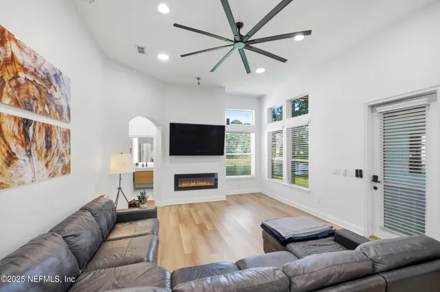 a living room with furniture a flat screen tv and a fireplace