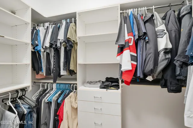 a view of walk in closet with clothes