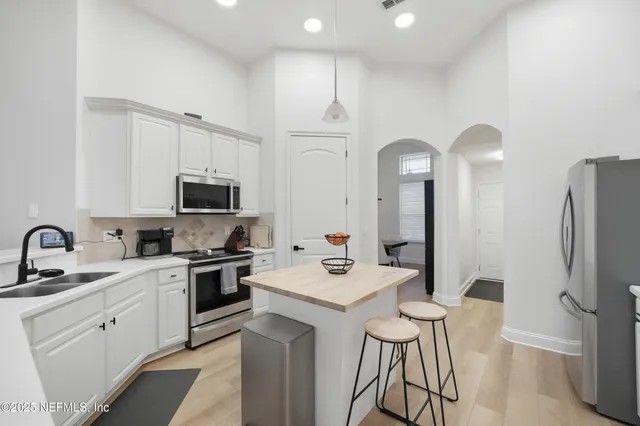 a kitchen with a sink stainless steel appliances and white cabinets