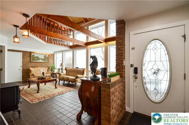 a living room with furniture a clock potted plants and a large window