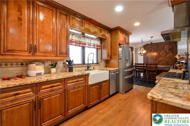 a kitchen with stainless steel appliances granite countertop a sink a stove and a refrigerator