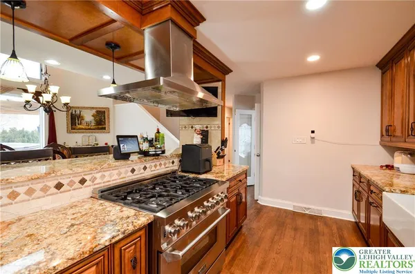 a kitchen with stainless steel appliances granite countertop a stove and a wooden floors