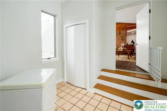 a view of a bedroom with wooden floor and white walls