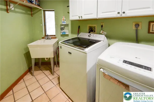 a room with washing machine and cabinets