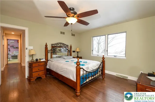 a bedroom with a bed and a flat tv screen on dresser