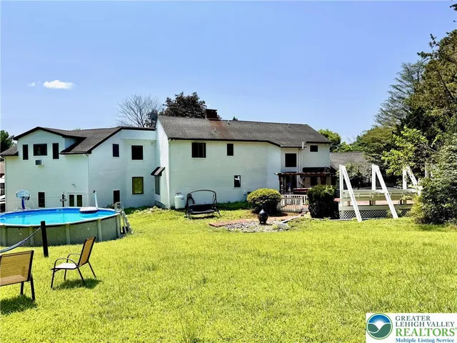a view of a house with swimming pool and sitting area