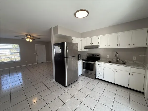 a kitchen with a refrigerator sink and cabinets