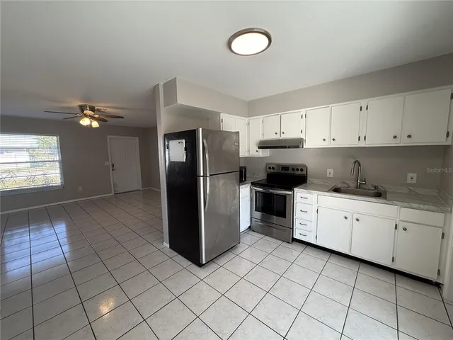 a kitchen with a refrigerator sink and cabinets