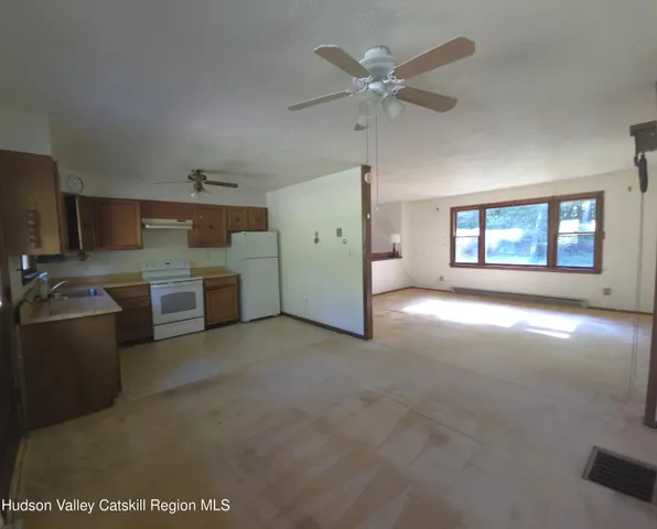 a view of a kitchen with a sink a ceiling fan and windows