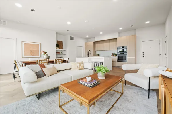 a living room with furniture and kitchen view