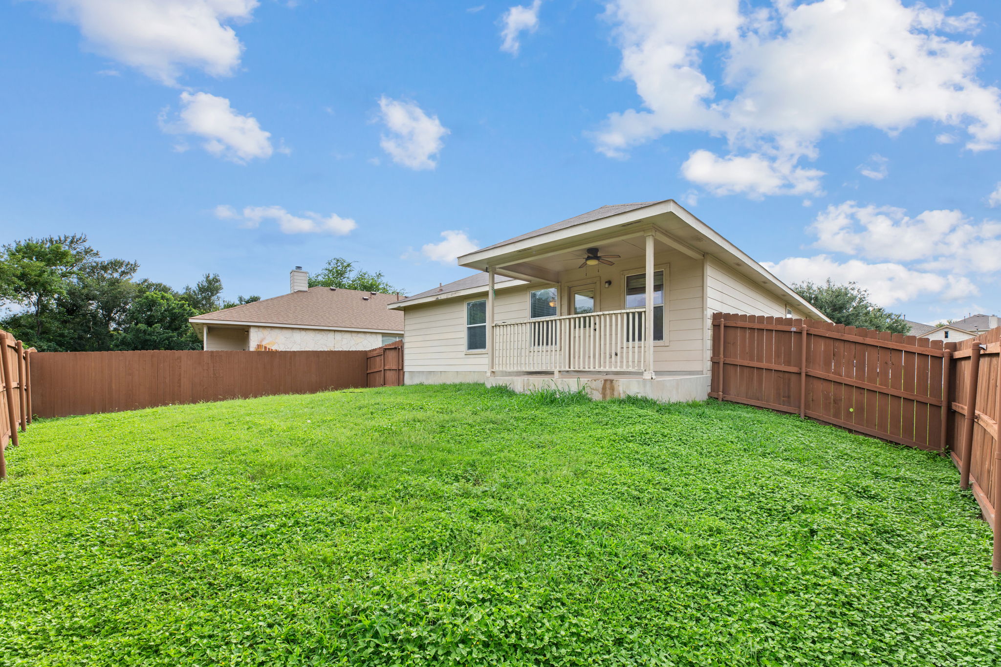 12601 Waynespur Lane Elgin, TX 78621 - Photo 36 of 38 A deep, verdant lawn cradles a cozy rear patio, offering a private outdoor retreat.