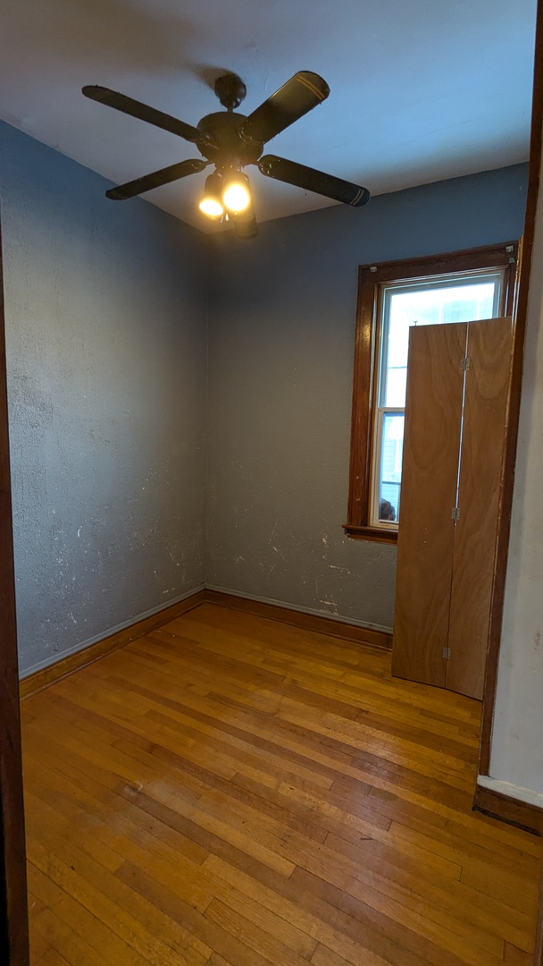 8112 South Exchange Avenue Chicago, IL 60617 - Photo 18 of 35 a view of an empty room with wooden floor and a window
