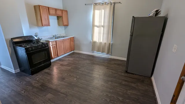 a view of a kitchen with wooden floor and electronic appliances