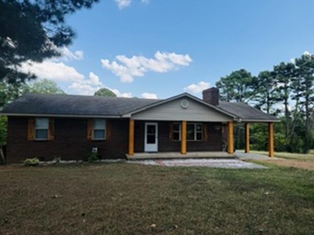 2158 Barlow Road Ripley, TN 38063 - Photo 12 of 18 Brick exterior with a covered front porch featuring wood support columns, a chimney, and a gabled entry