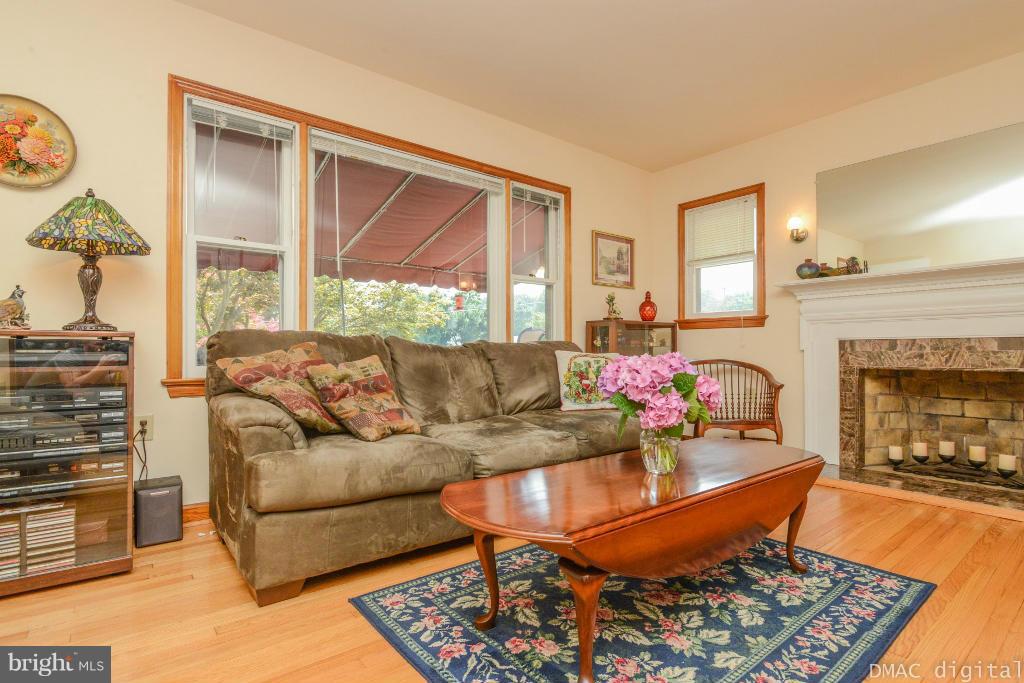 9030 Bethel Road Frederick, MD 21702 - Photo 4 of 28 a living room with furniture a fireplace and a floor to ceiling window