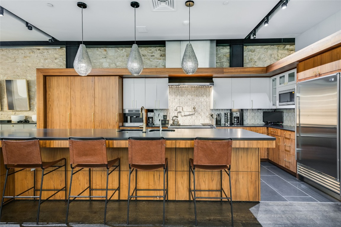 811 Congress Avenue Austin, TX 78701 - Photo 8 of 39 a kitchen with stainless steel appliances granite countertop a table chairs in it and wooden floors