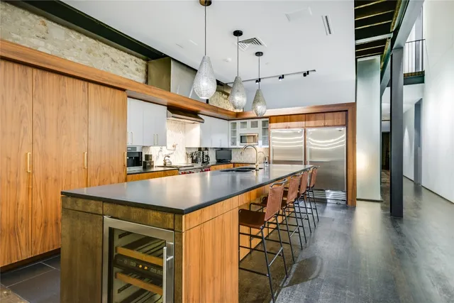 a kitchen with stainless steel appliances granite countertop a sink a stove and a refrigerator